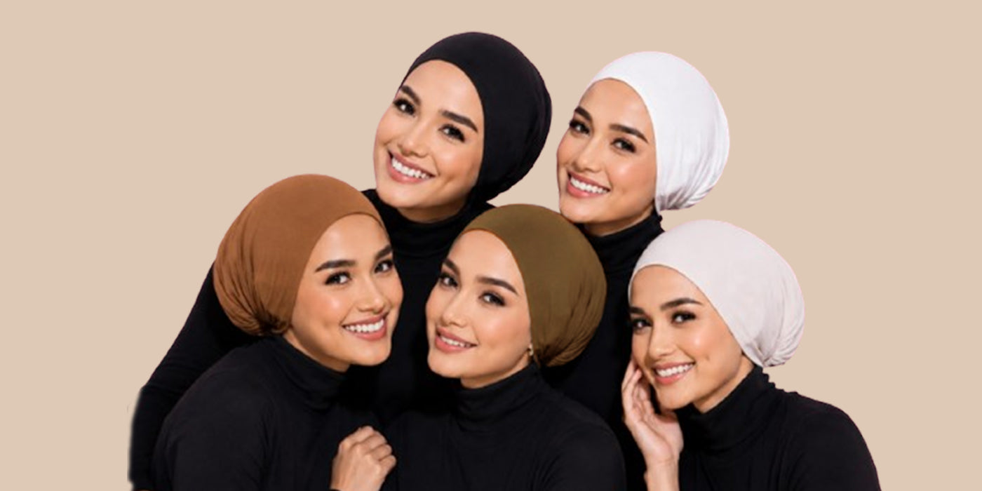 Five smiling women wearing black, white, brown, olive green, and light gray hijab undercaps with black turtlenecks, posed together against a beige background — Zoya Z modest fashion