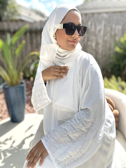 Model wearing Noor Pearl White Abaya with pearl sleeves and matching belt