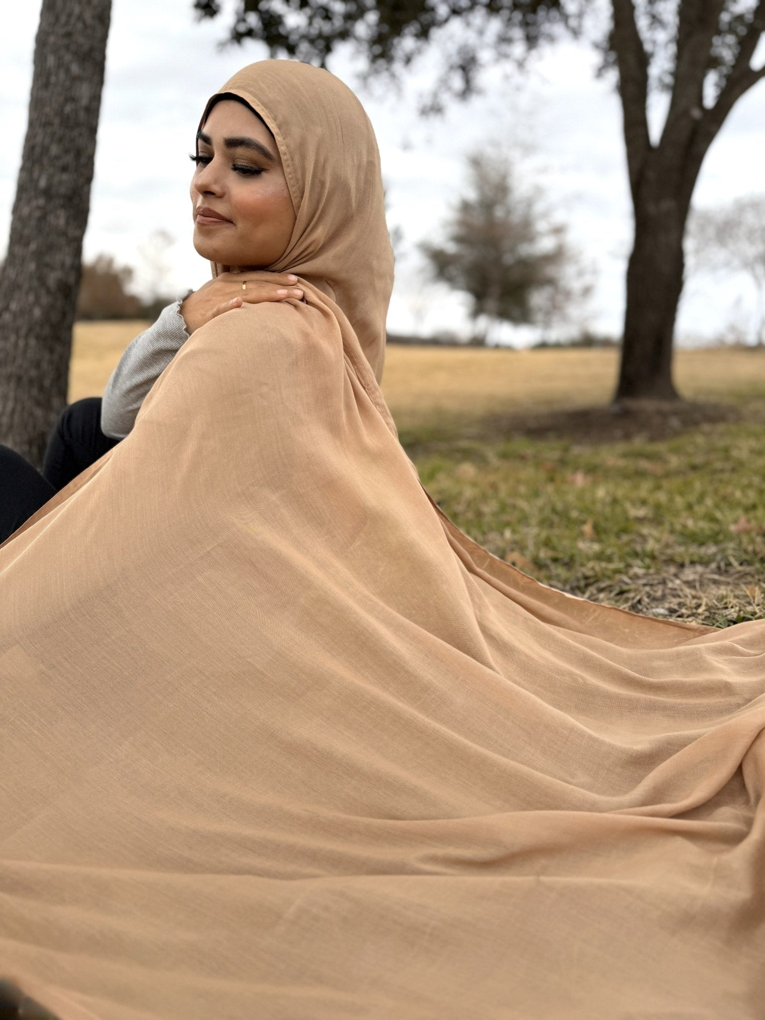 Soft beige modal hijab with airy, lightweight drape, breathable fabric styled casually outdoors for everyday wear