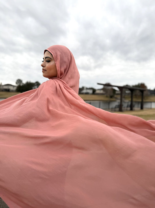 Pink modal hijab with soft, flowing drape and lightweight breathable fabric, styled outdoors for everyday modest wear