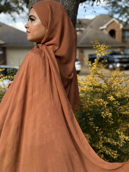 Burnt modal hijab with soft drape and breathable fabric, styled outdoors for elegant everyday modest wear
